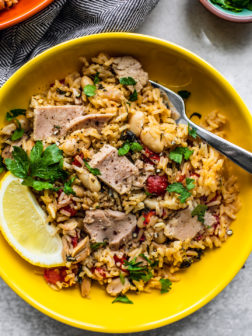 Bowl of Mediterranean Instant Pot Rice with Tuna in bright yellow bowl.