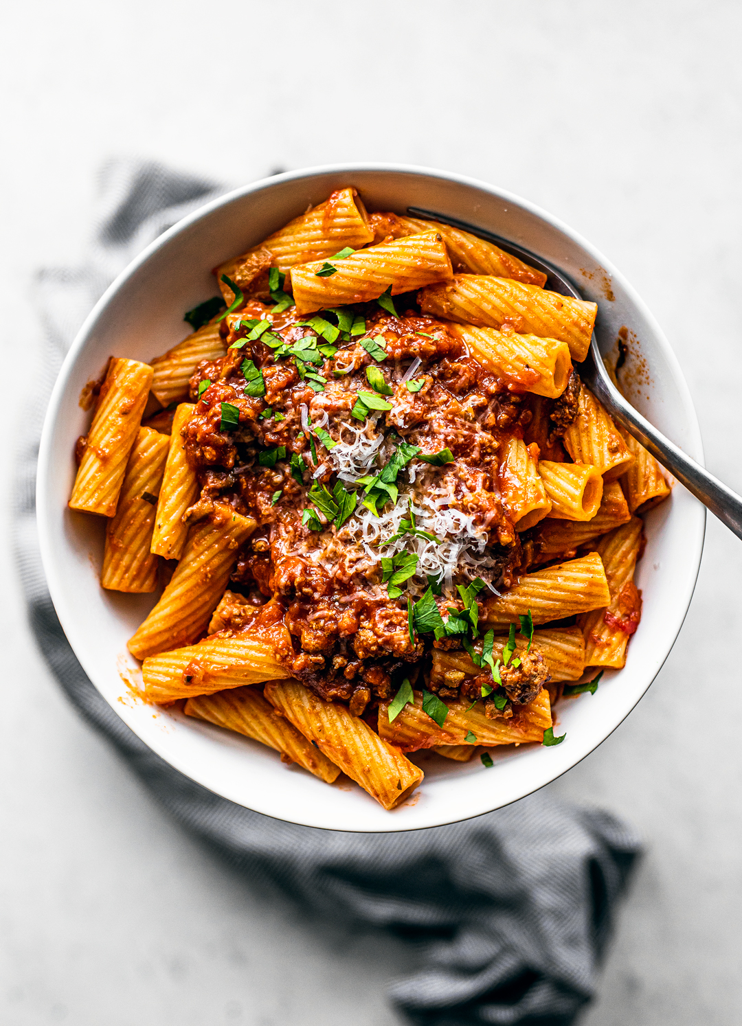 Overhead shot of bowl of rigatoni topped with turkey bolognese.