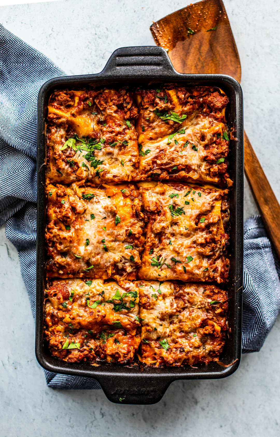 Overhead shot of cheesy lasagna cut into squares.