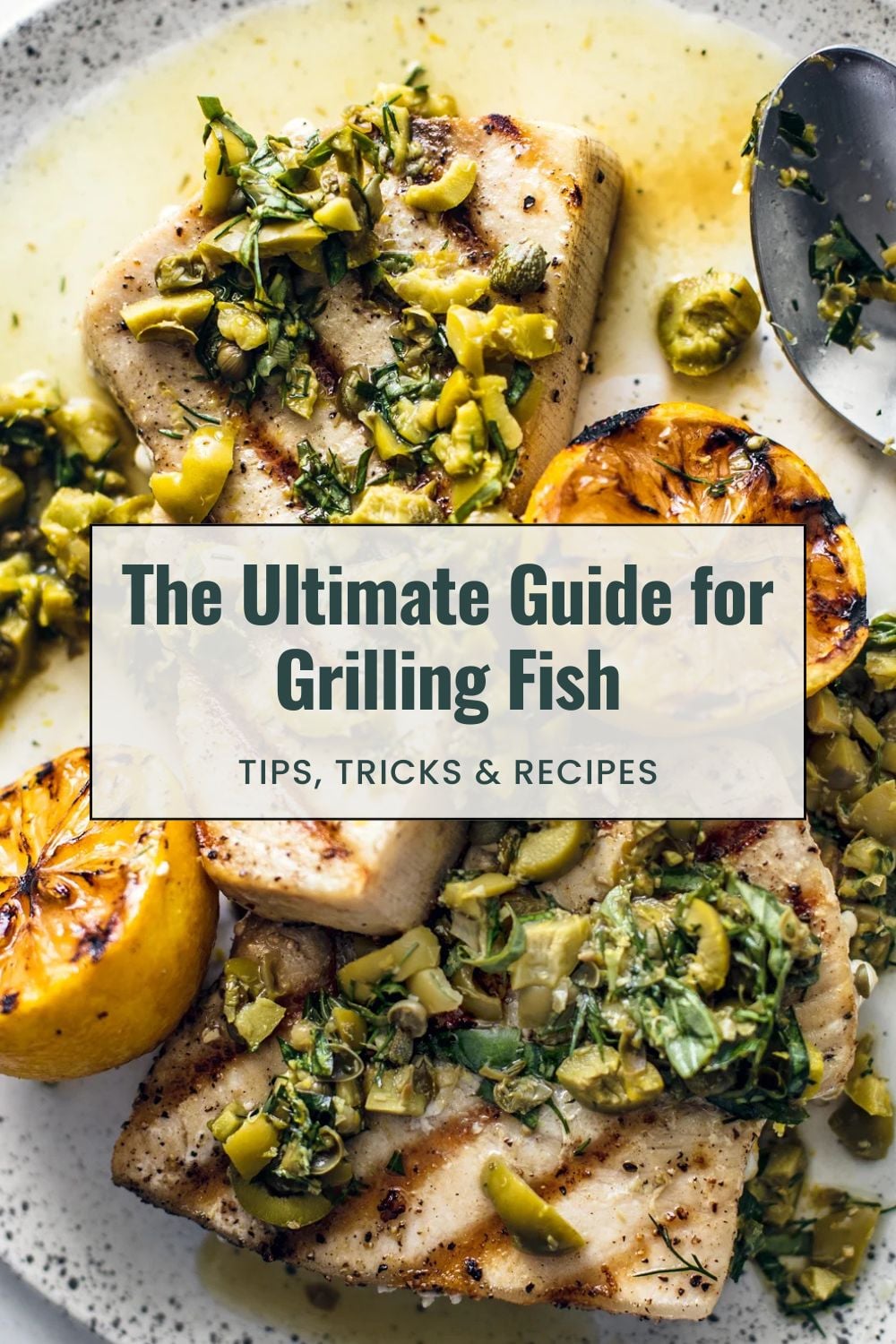 Grilled swordfish fillets on serving plate with chopped herbs and olives.