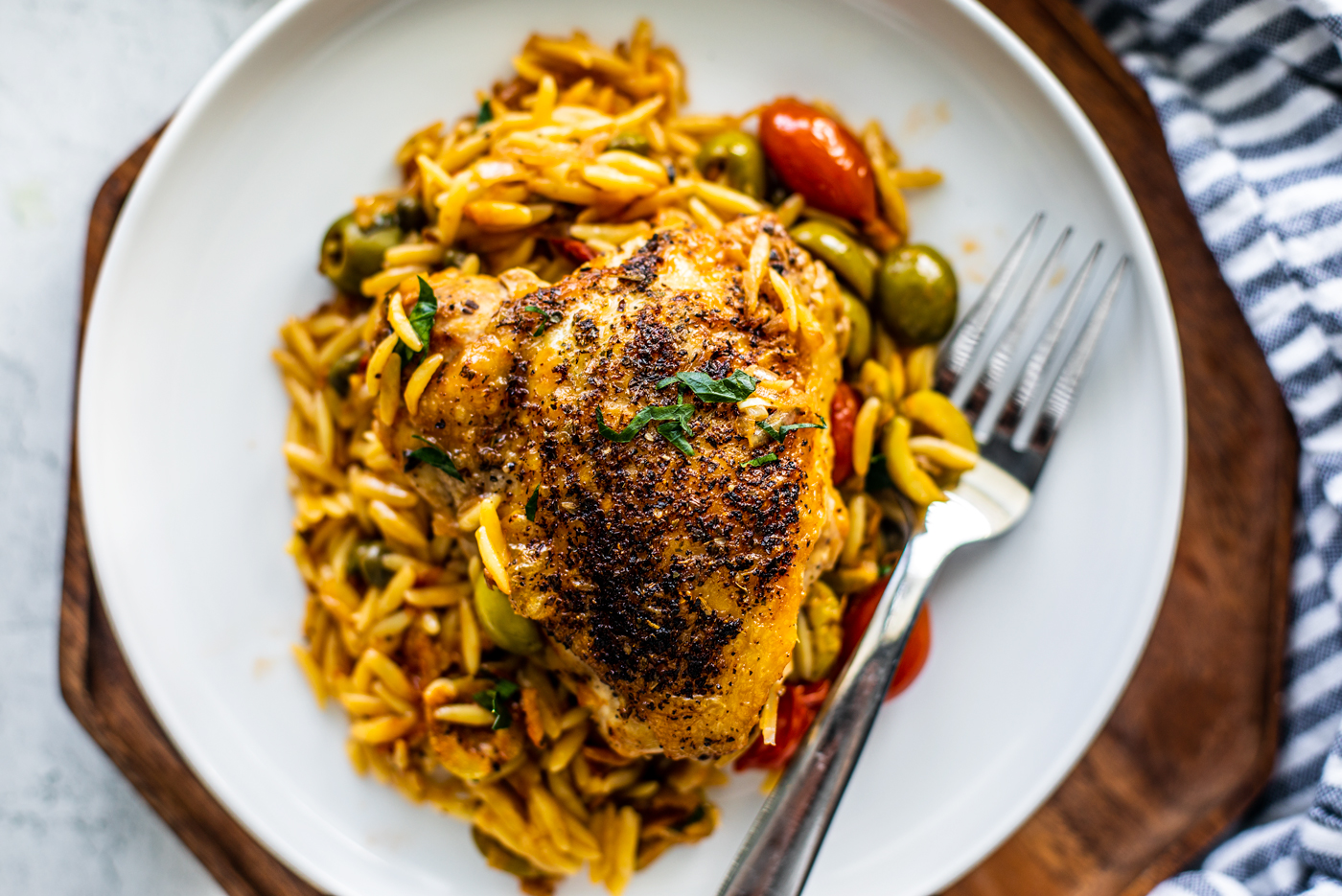 Overhead shot of plateful of orzo with crispy chicken on top.