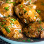 Close up side shot of saucy chicken thighs in braiser.