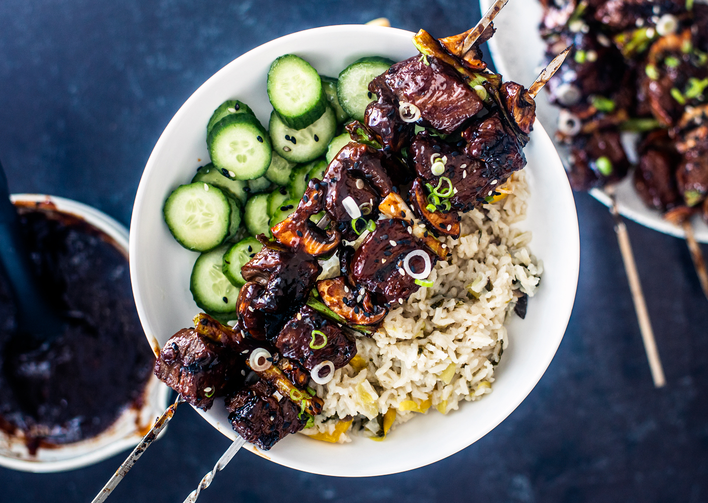 Overhead shot of plate of rice, cucumber salad, and Korean BBQ Beef Skewers.