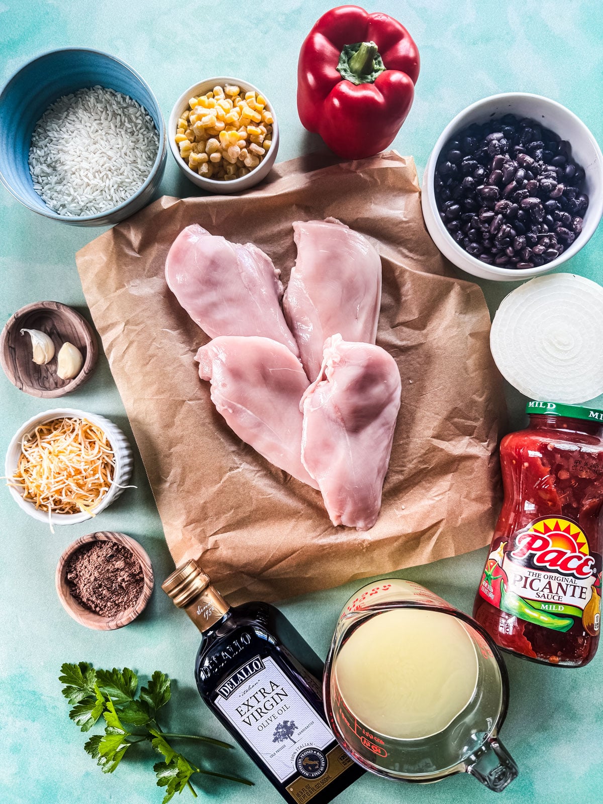 Ingredients for Tex-Mex chicken and rice bake on a blue background.