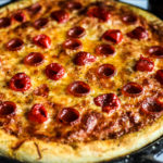 Side close up of pizza in cast iron pizza pan.