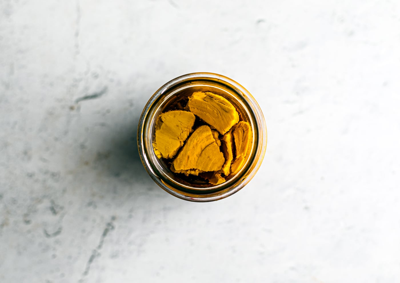 Overhead shot of big tuna fillets neatly placed in jar.