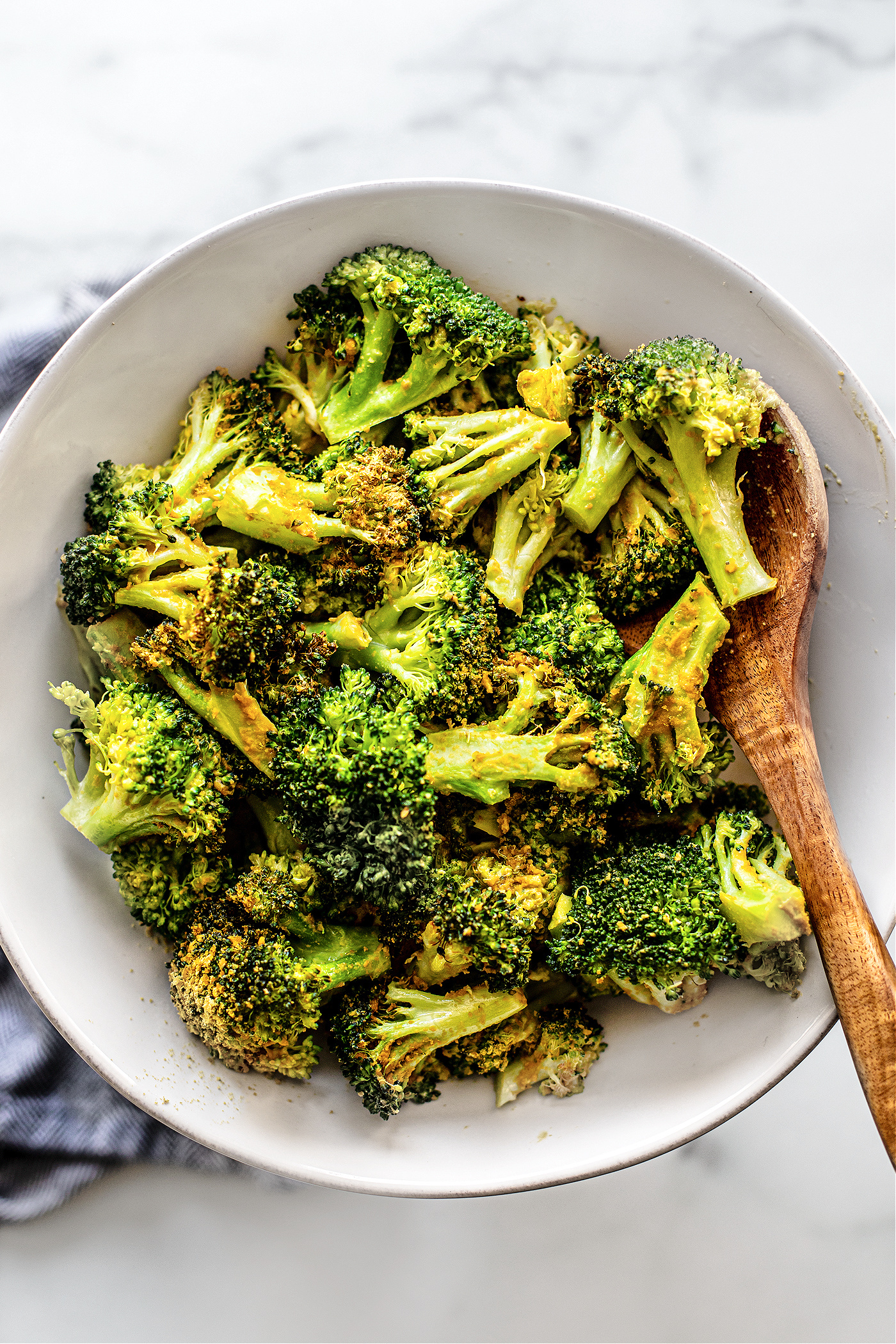 White serving bowl full of cooked air fryer broccoli florets.