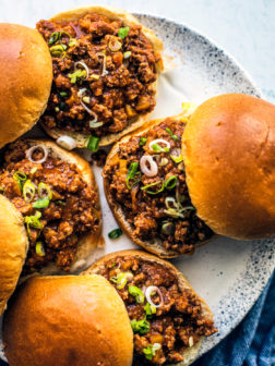 Sloppy Joes on a serving platter with a blue hand towel on the side.