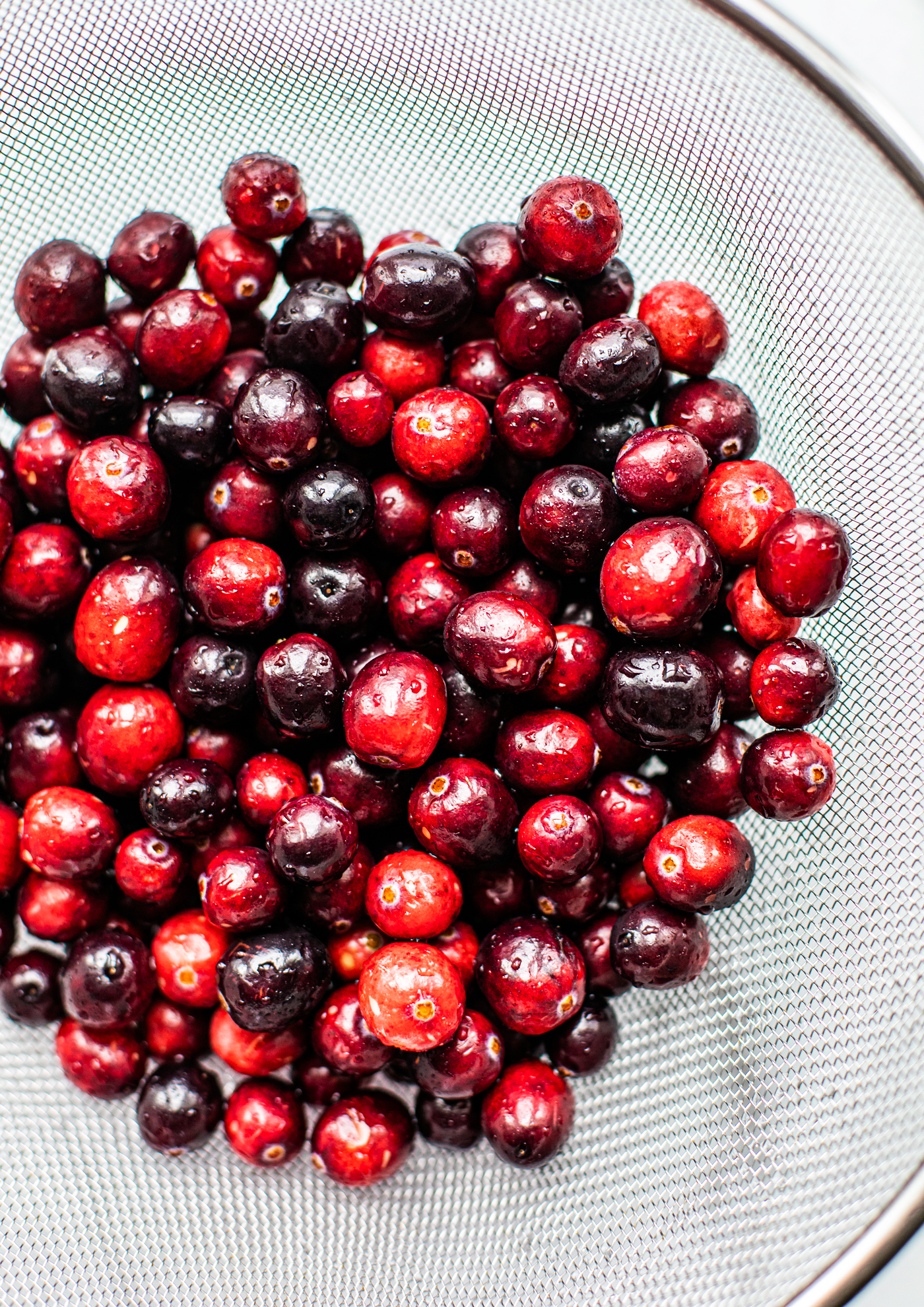 Close up of fresh cranberries in a colander.