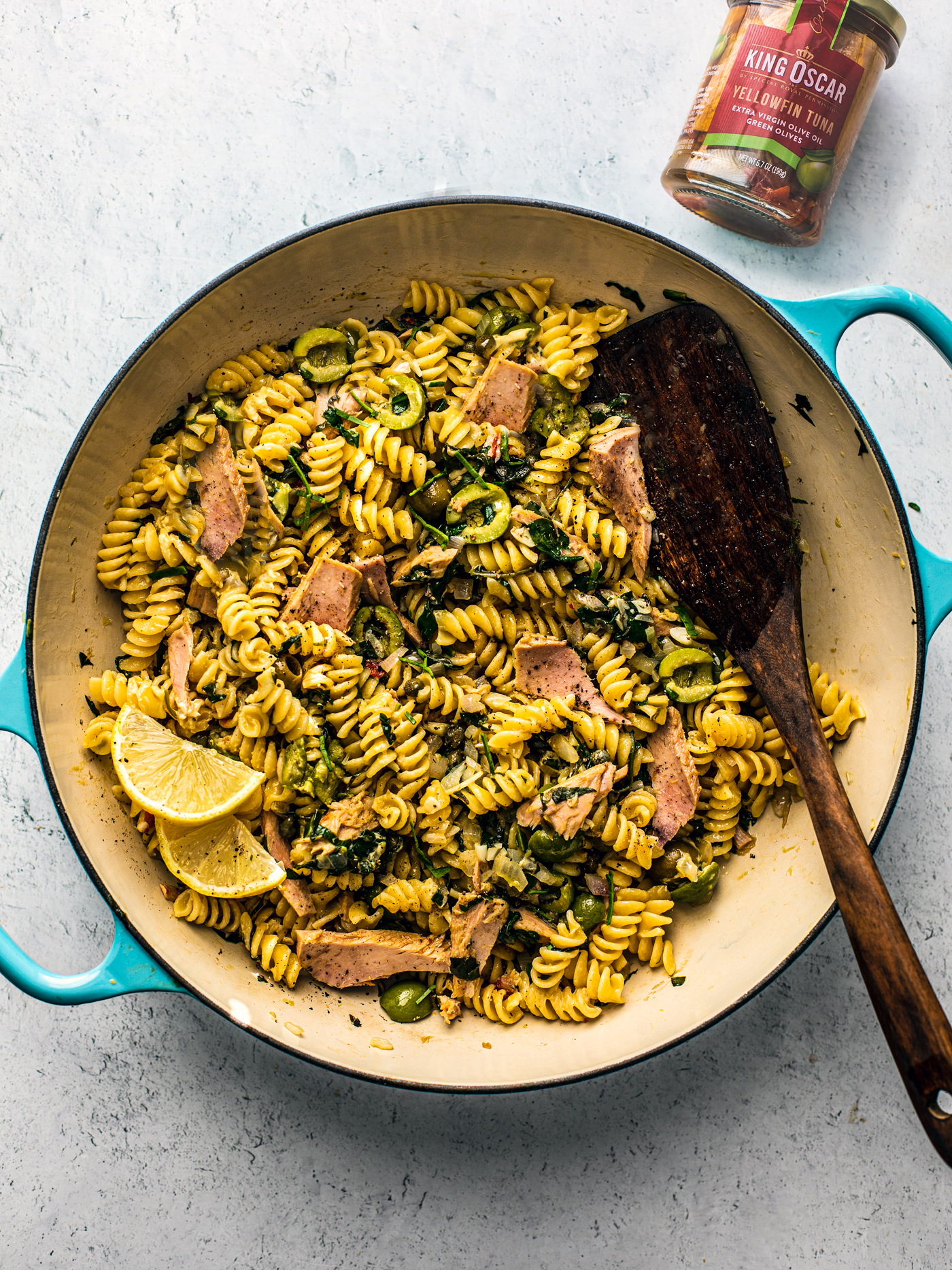 Pan of pasta with spinach and tuna, and a jar of King Oscar tuna next to it.