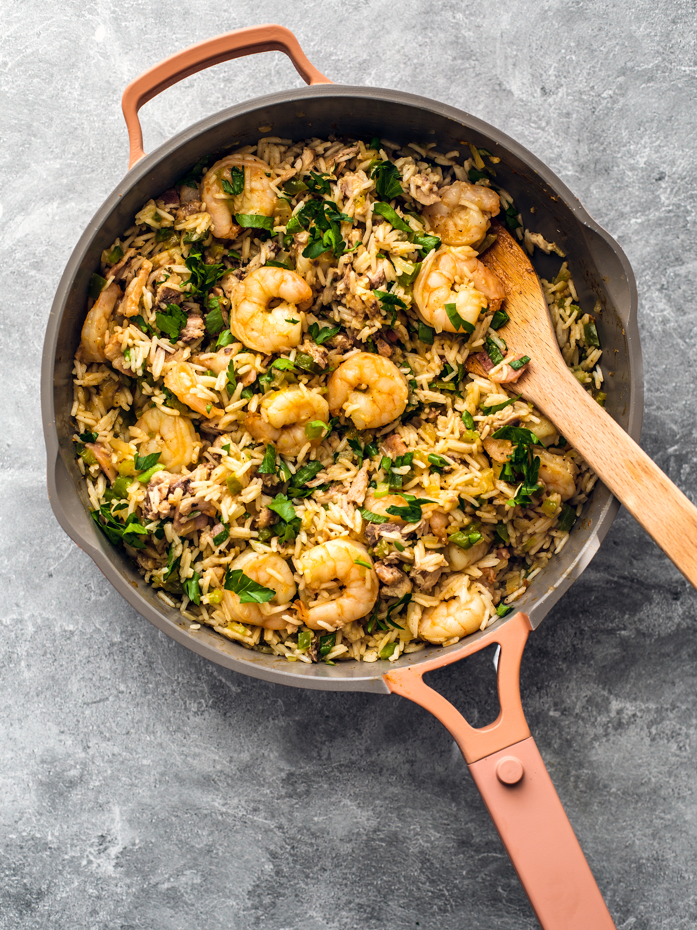 Pan full of dirty rice and shrimp, garnished with fresh parsley.
