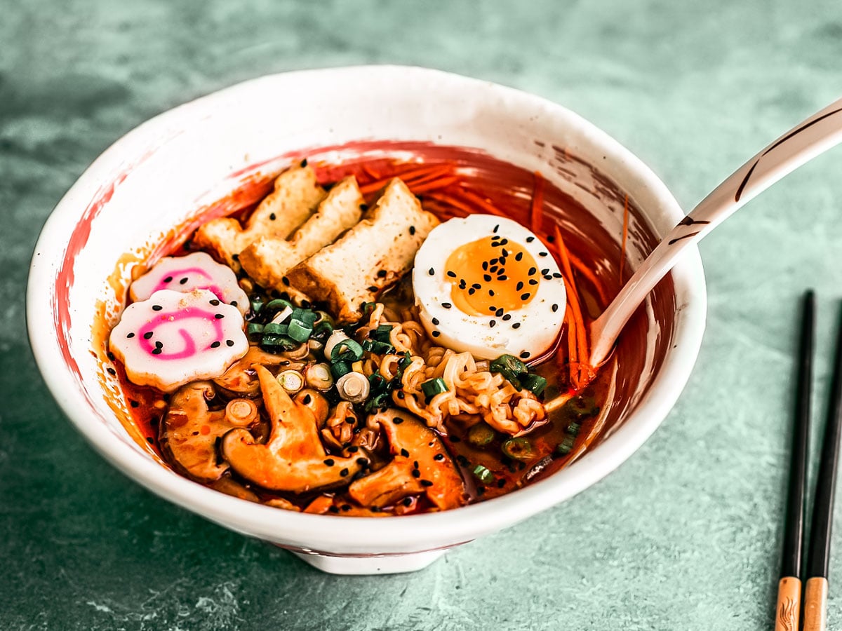 Spicy Shoyu Ramen in a ramen bowl with tofu and veggie garnishes.