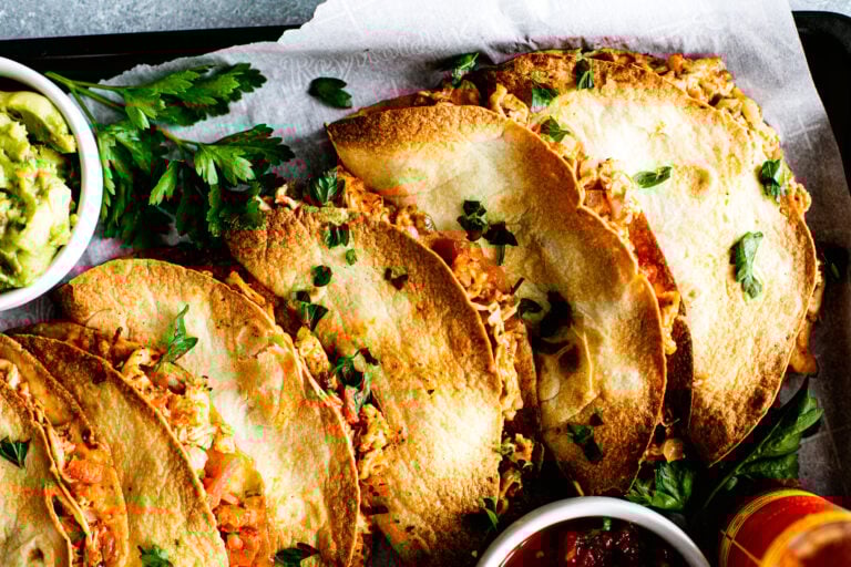 Close up of baked chicken tacos on serving pan.