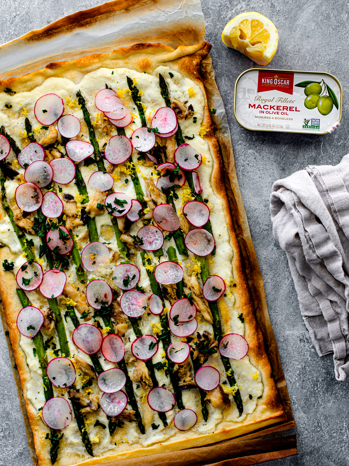 Asparagus and mackerel flatbread on parchment with can of King Oscar mackerel next to it.