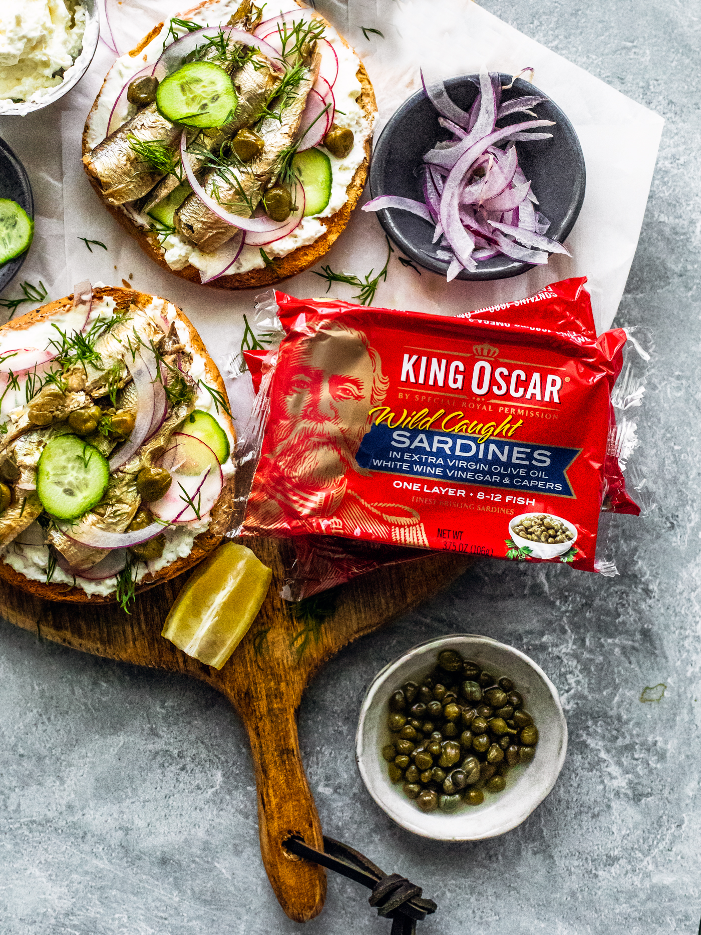 Package of King Oscar sardines with bagels on serving board.