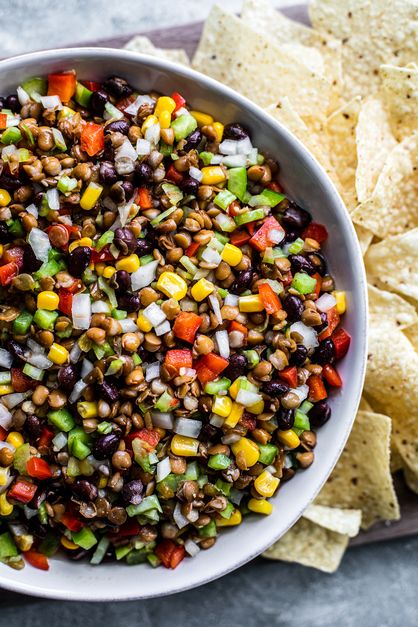 Close up of bowl of cowboy caviar with tortilla chips on the side of the bowl.