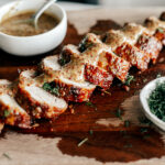 Side shot of sliced pork tenderloin with maple mustard sauce.