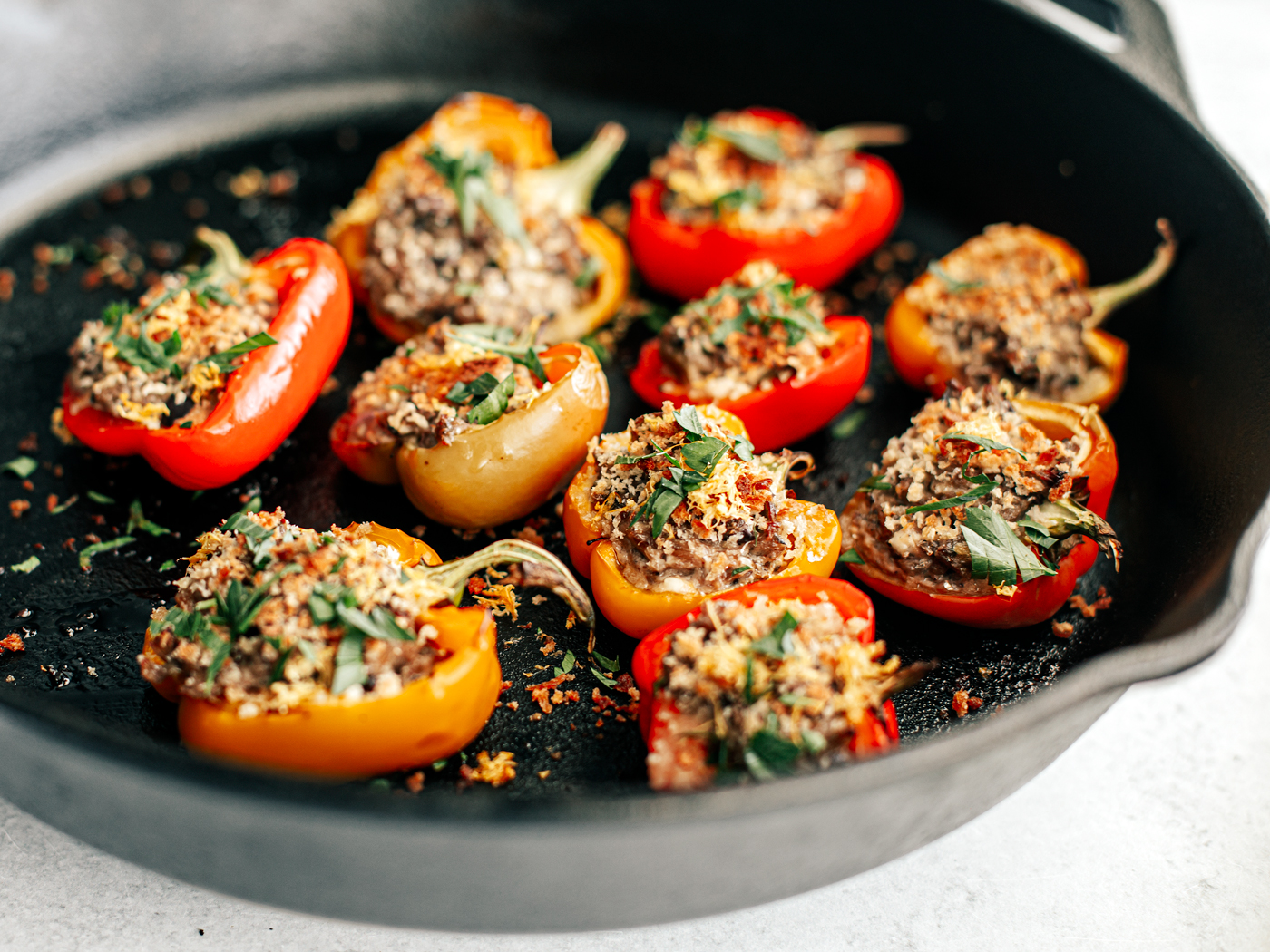 Side shot of stuffed peppers in cast iron pan.