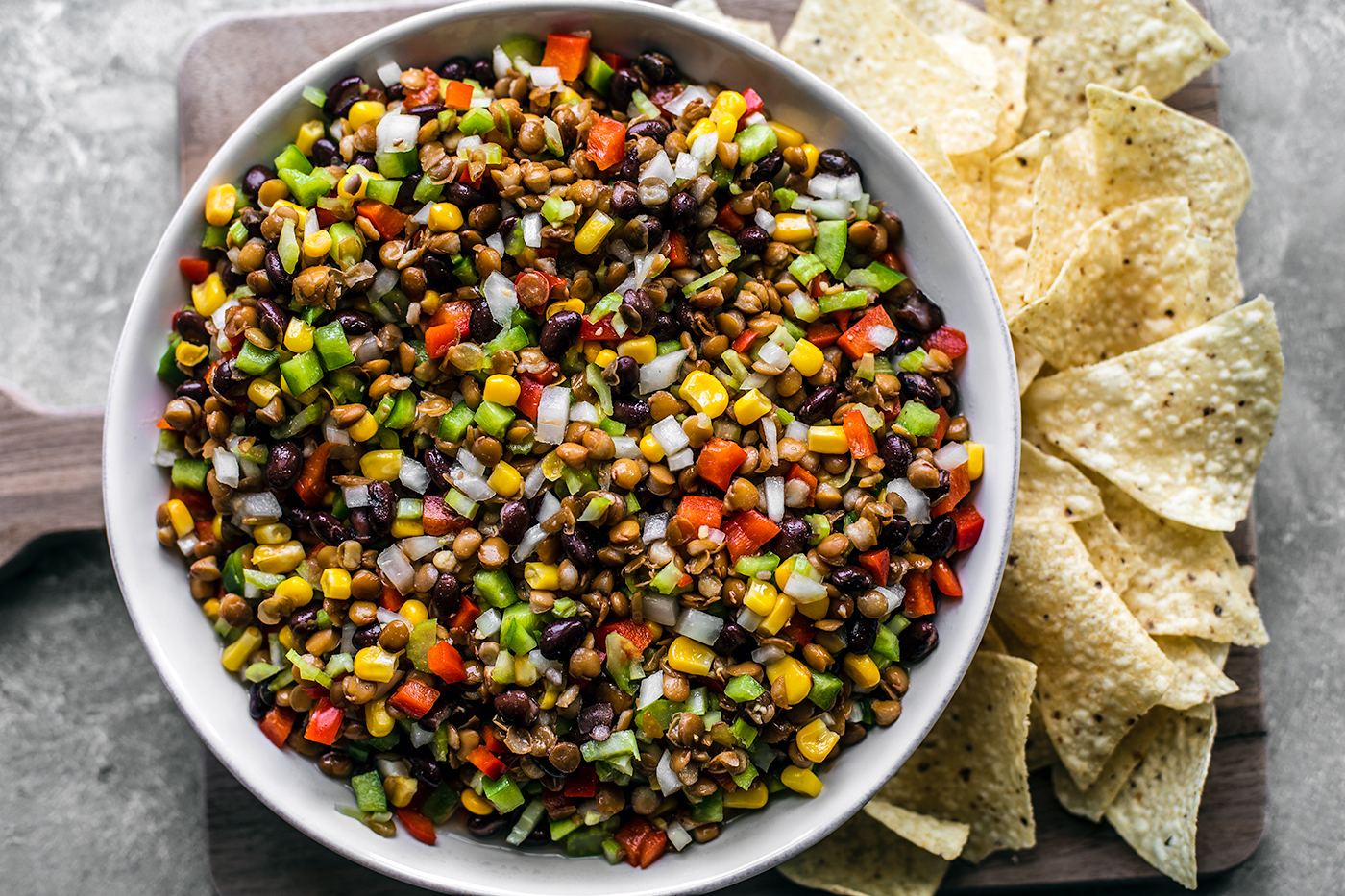 Close up of bowl of texas caviar with tortilla chips on the side of the bowl.