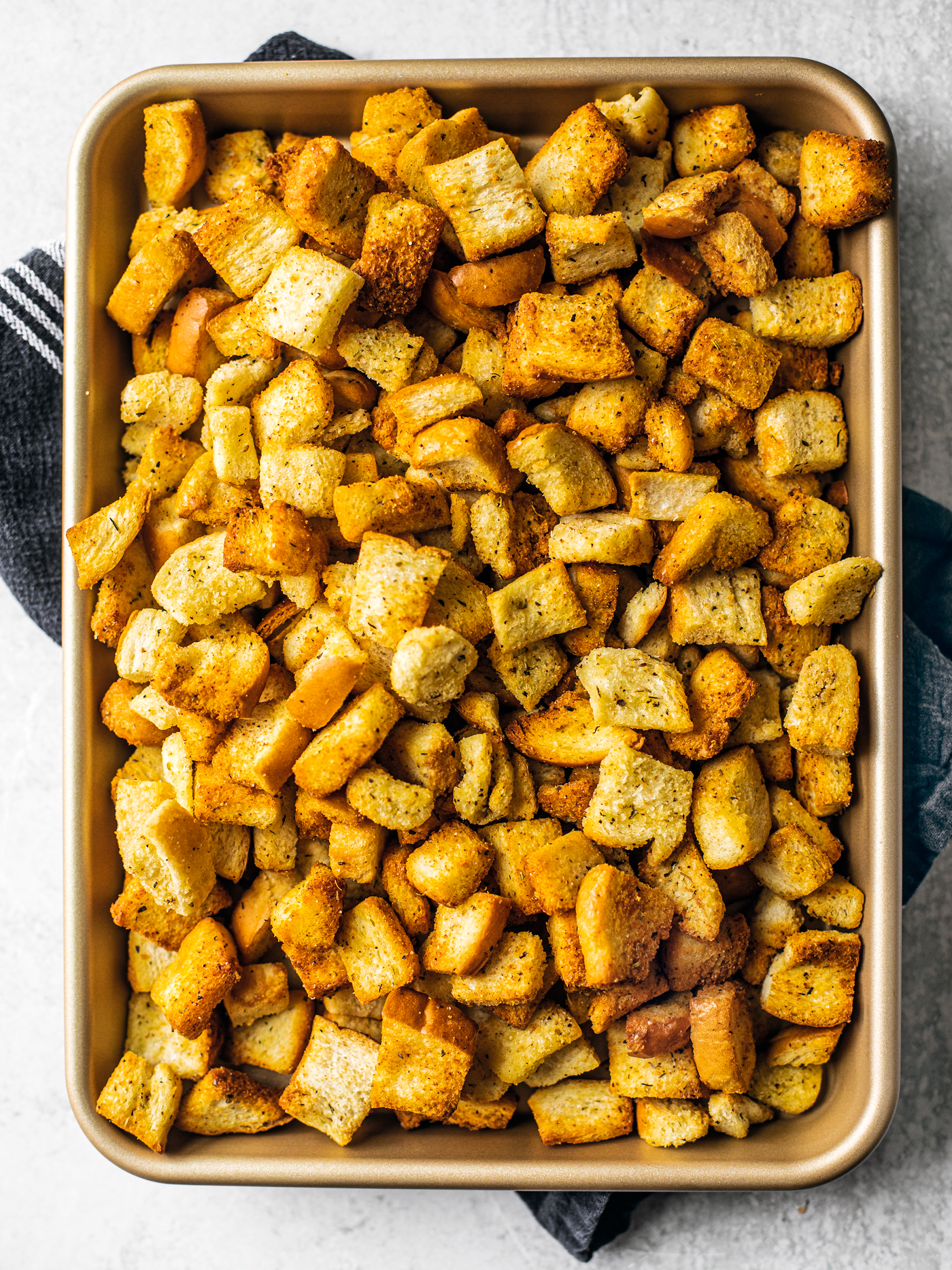 Baking sheet with golden homemade croutons on it.