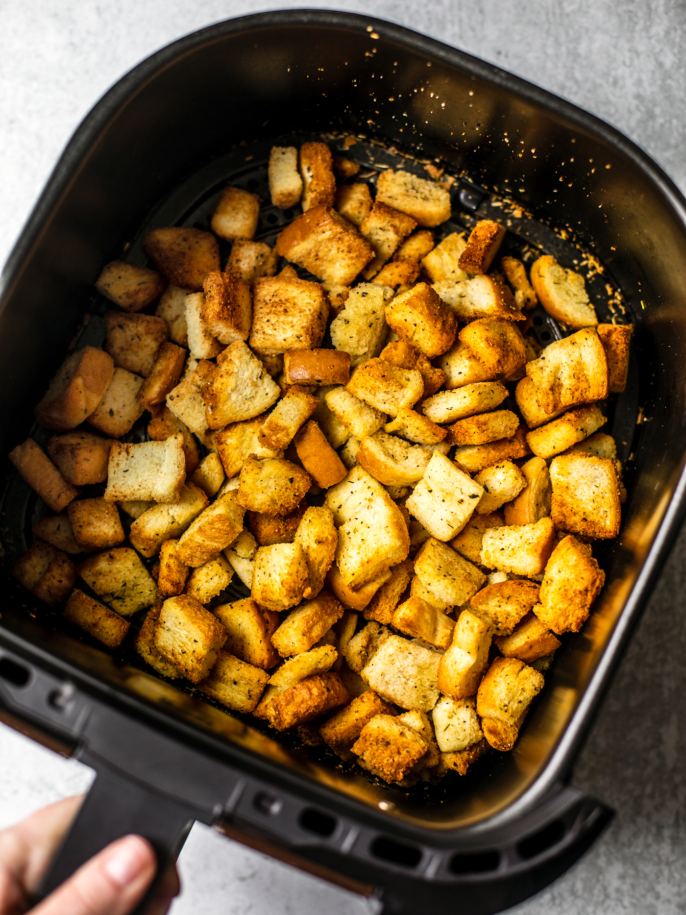 Air fryer full of toasted croutons.