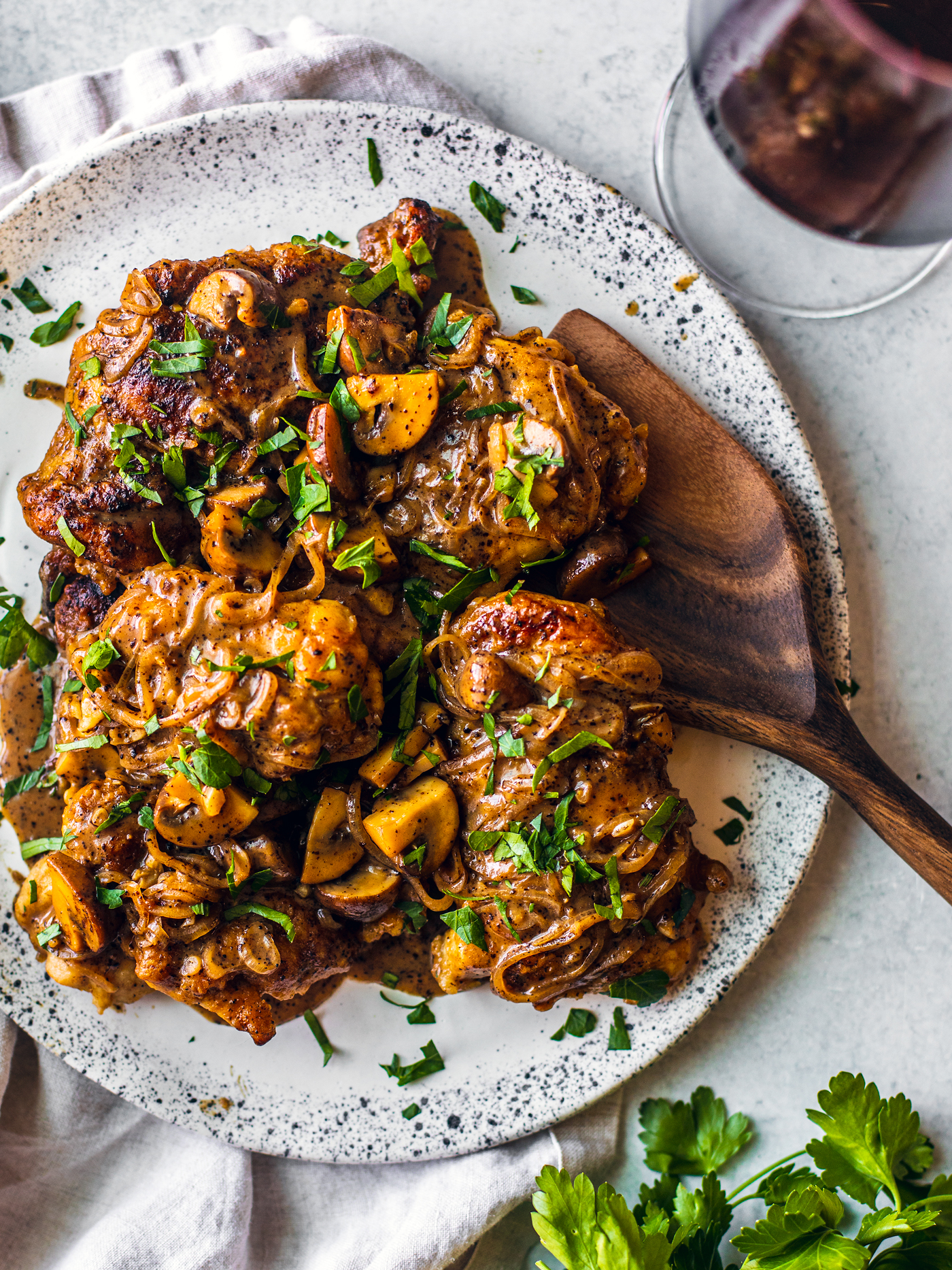 Serving plate of chicken marsala garnished with fresh parsley.