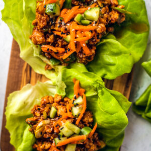 Close up of chicken lettuce wraps on a wooden serving board.