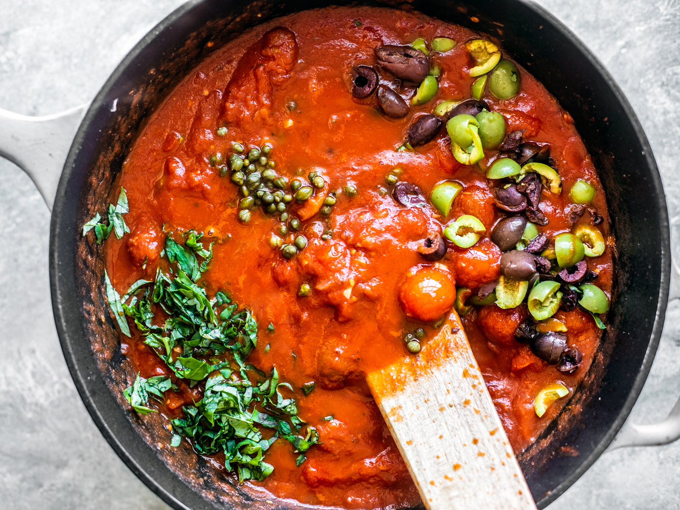 Red sauce with olives, fresh basil, and capers.