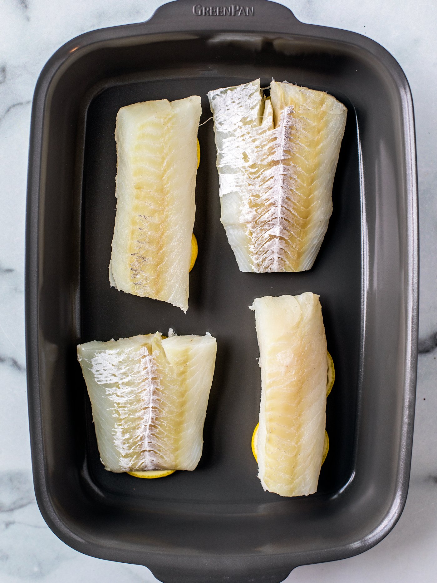 Baking dish with four cod fillets.