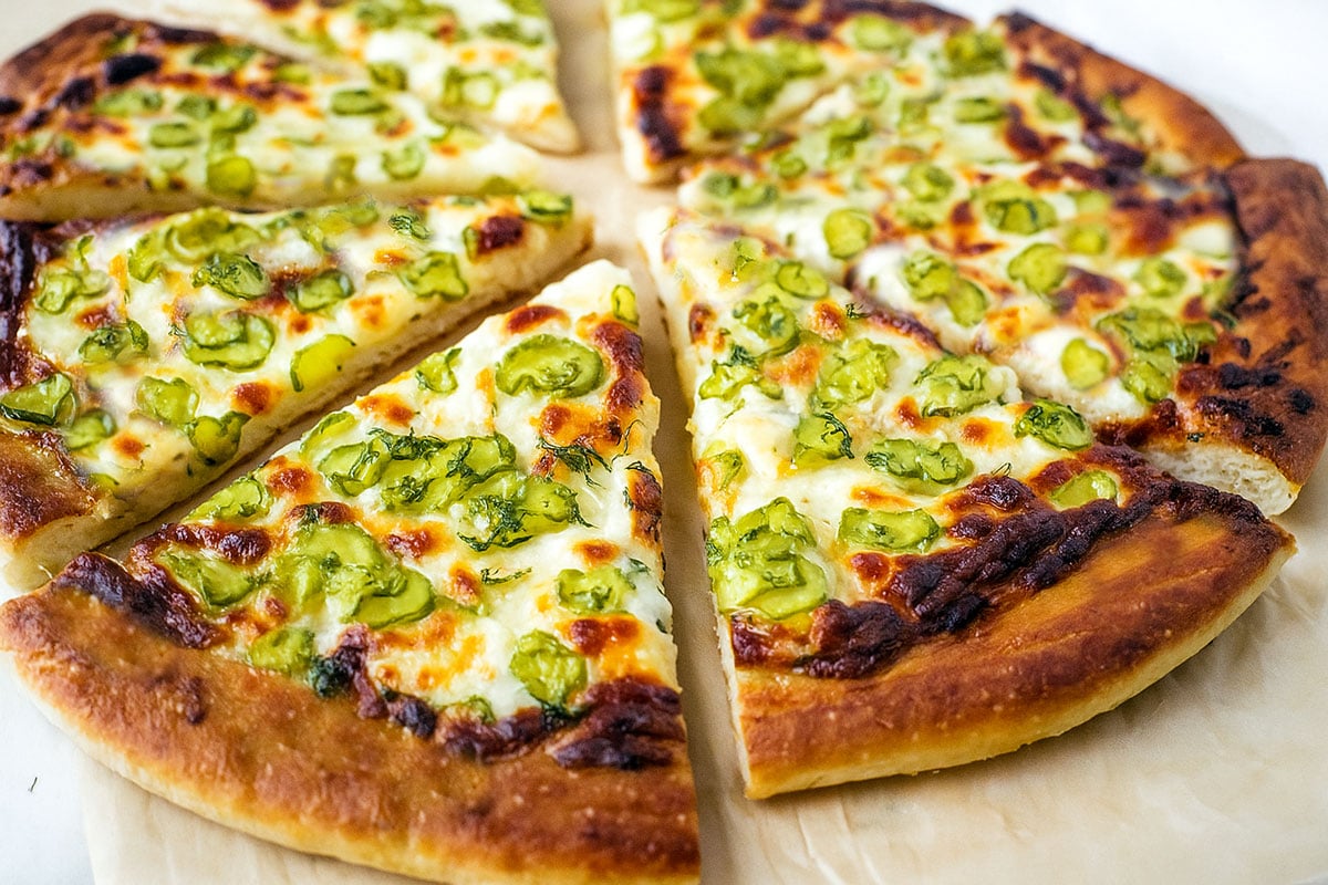 Dill pickle pizza slices on parchment paper.