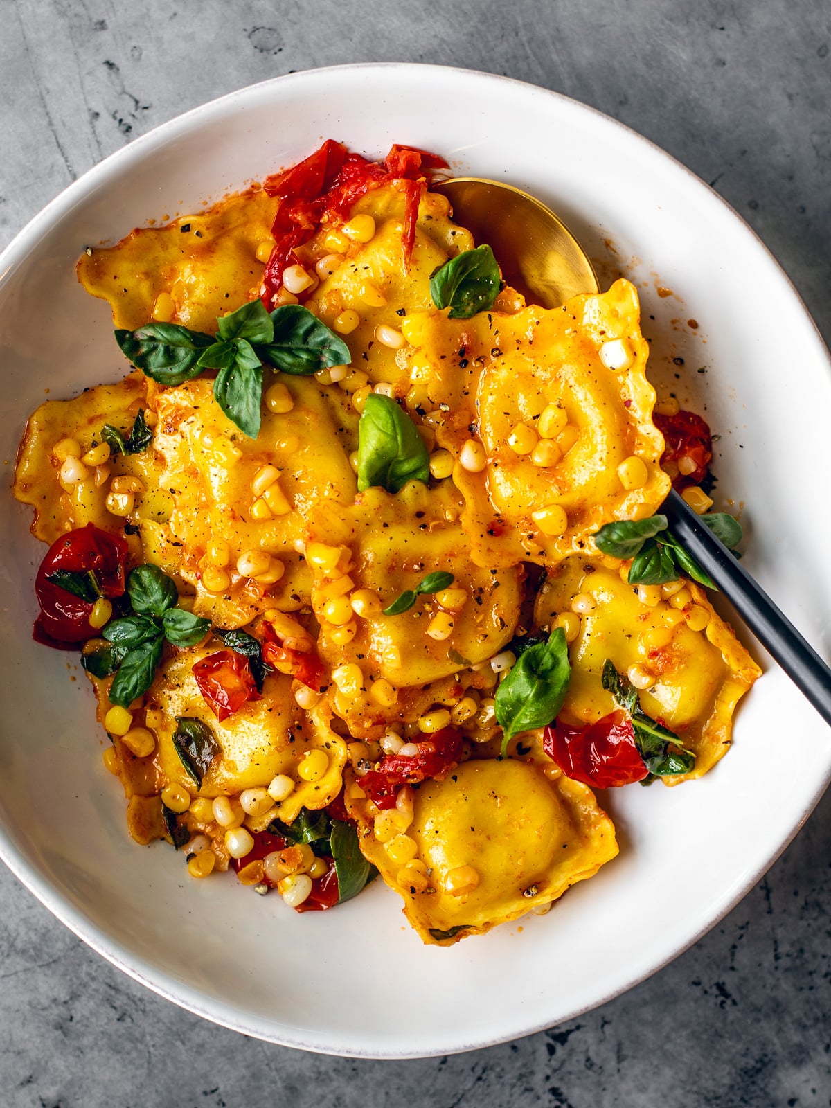Ravioli and veggies in a serving bowl.