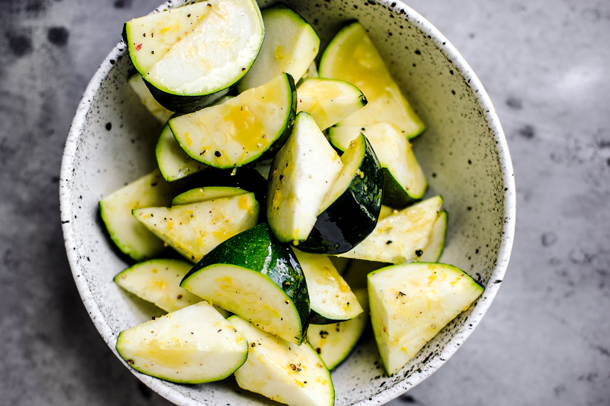 Chopped zucchini in a bowl with lemon zest.