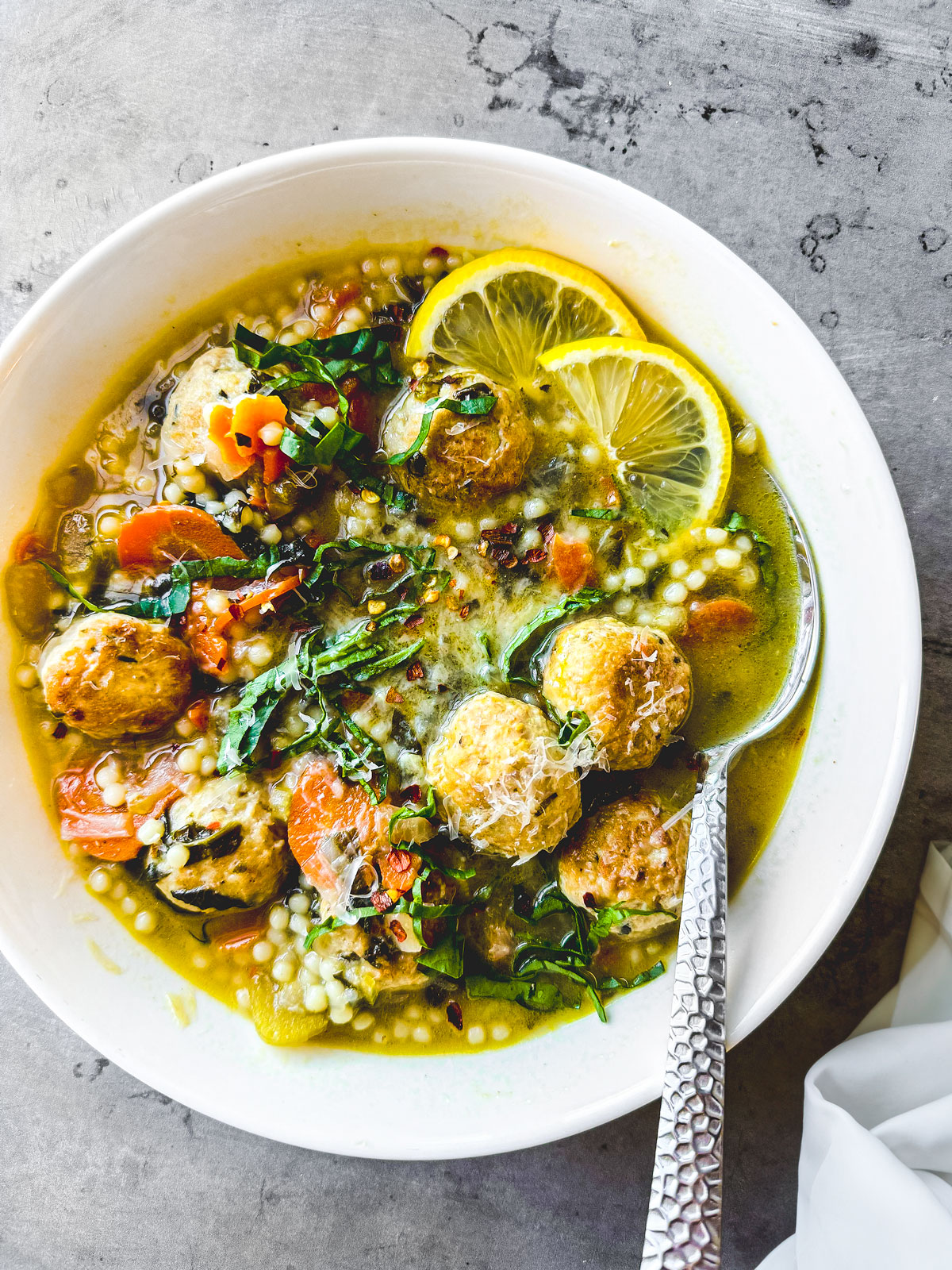 A bowl of Italian wedding soup with chicken meatballs.