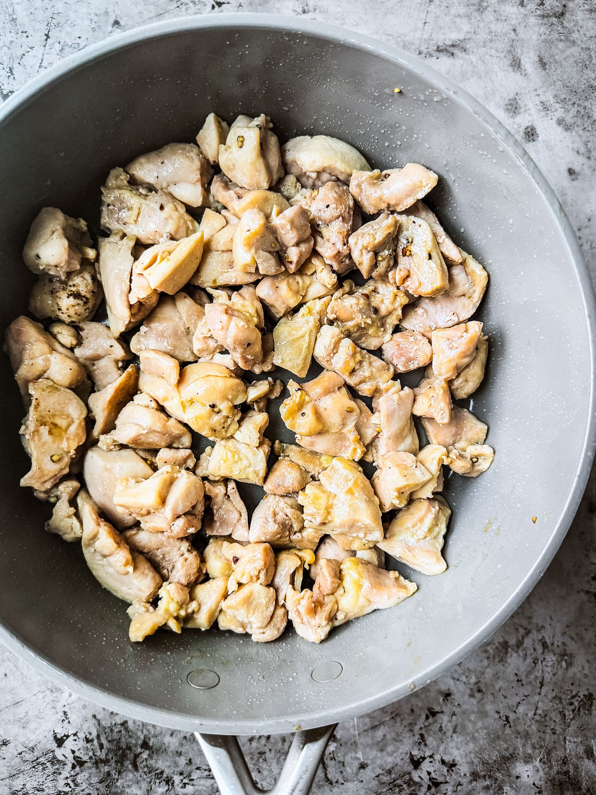 Diced chicken in a saut&eacute; pan.