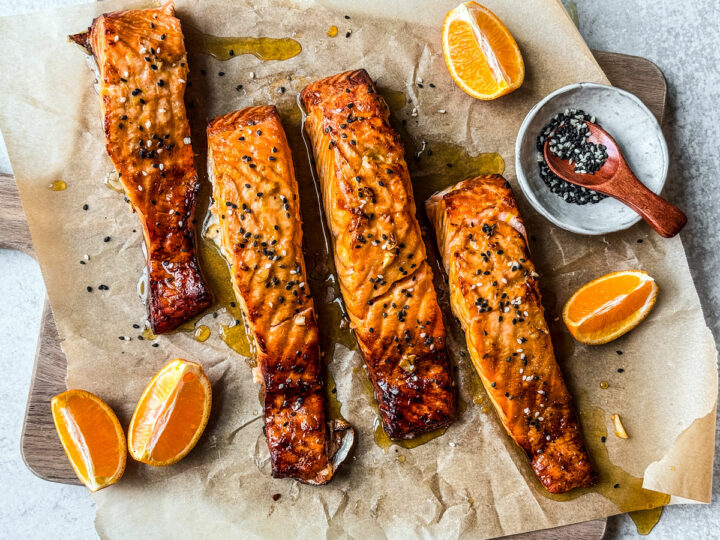 Fillets of salmon with orange honey glaze on a serving board.