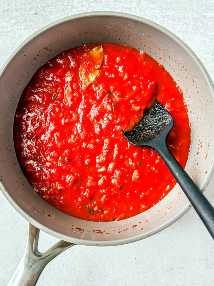 Marinara in a pan with herbs stirred in.
