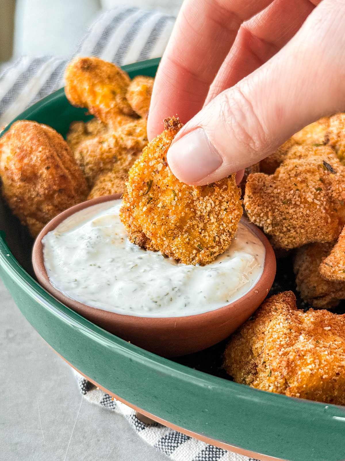 Hand dipping nugget into Ranch dip.