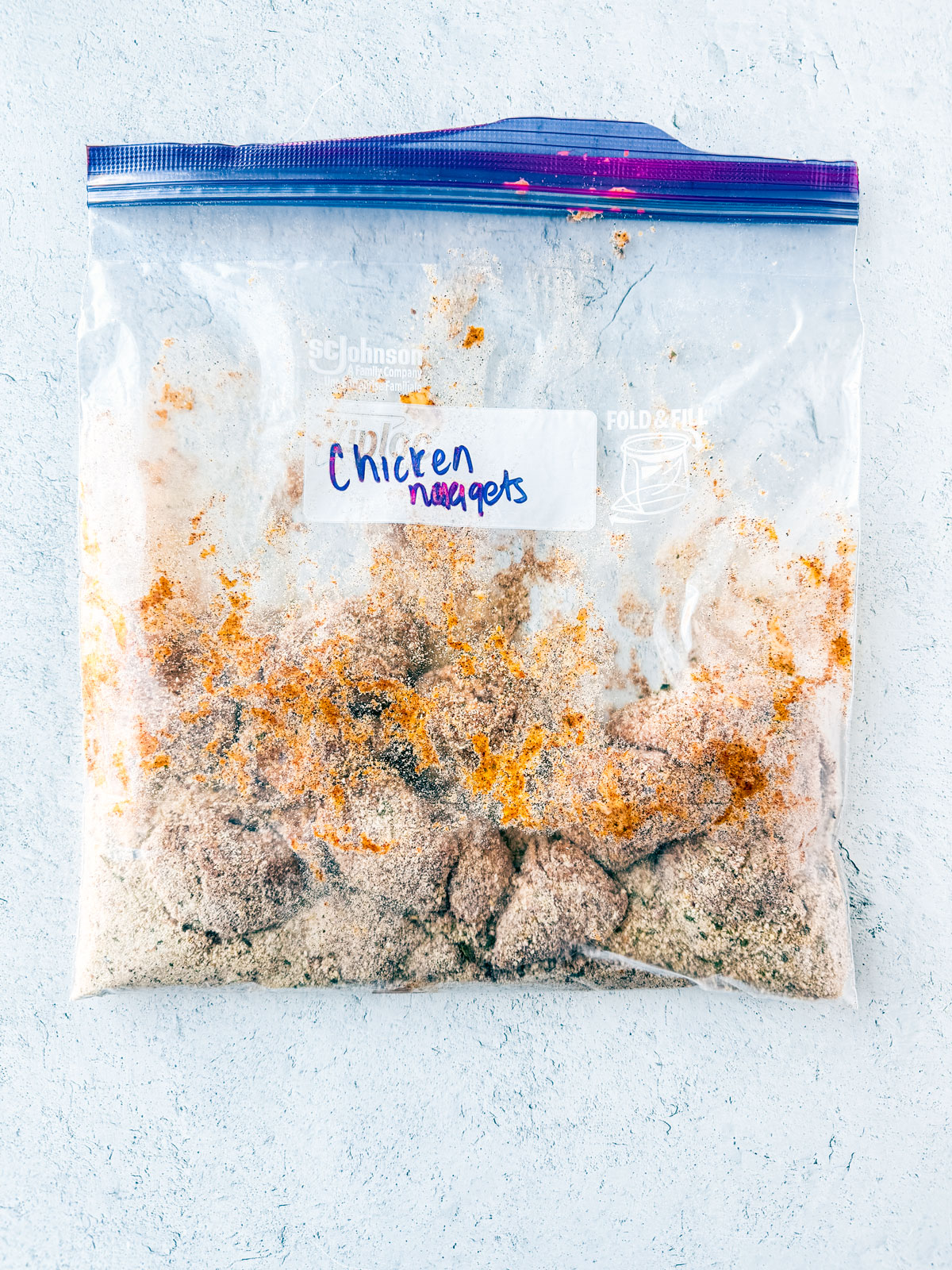 Chicken nuggets in a zip-top bag of breading.