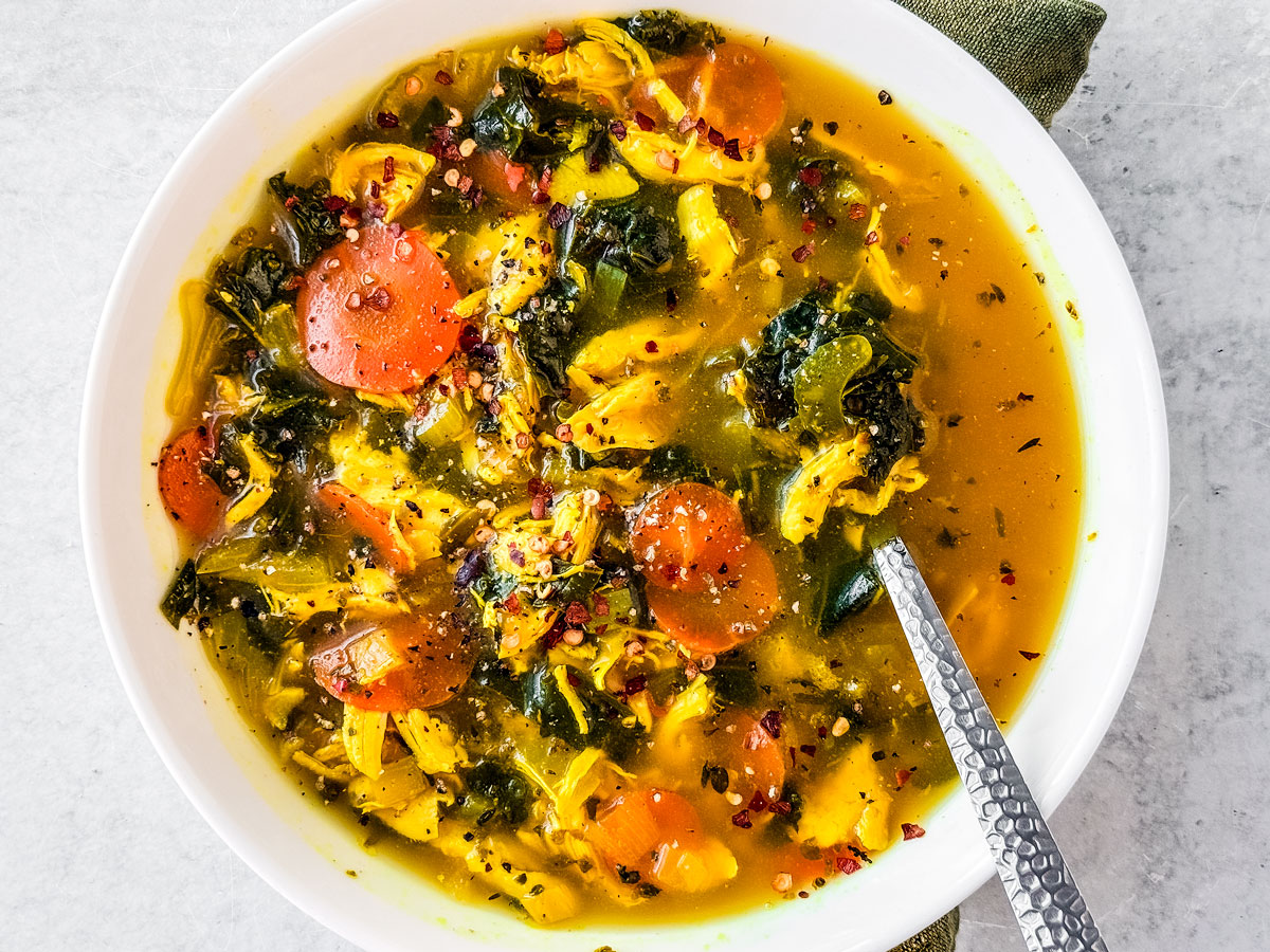 Bowl of chicken soup with turmeric and ginger.
