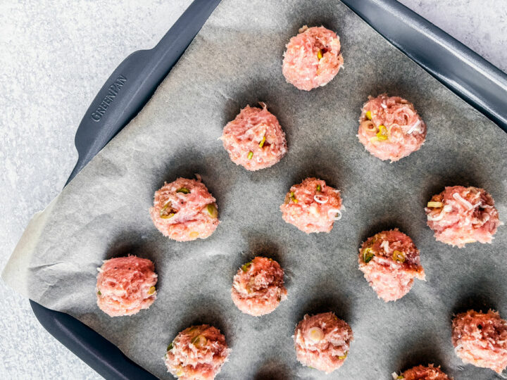 Turkey meatballs on a parchment-lined baking sheet.