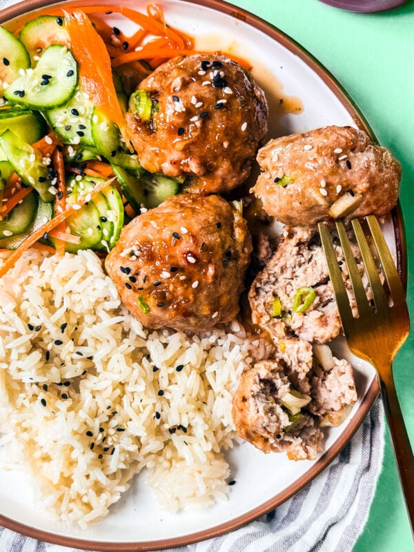 Baked turkey meatballs with honey glaze on a plate with rice.