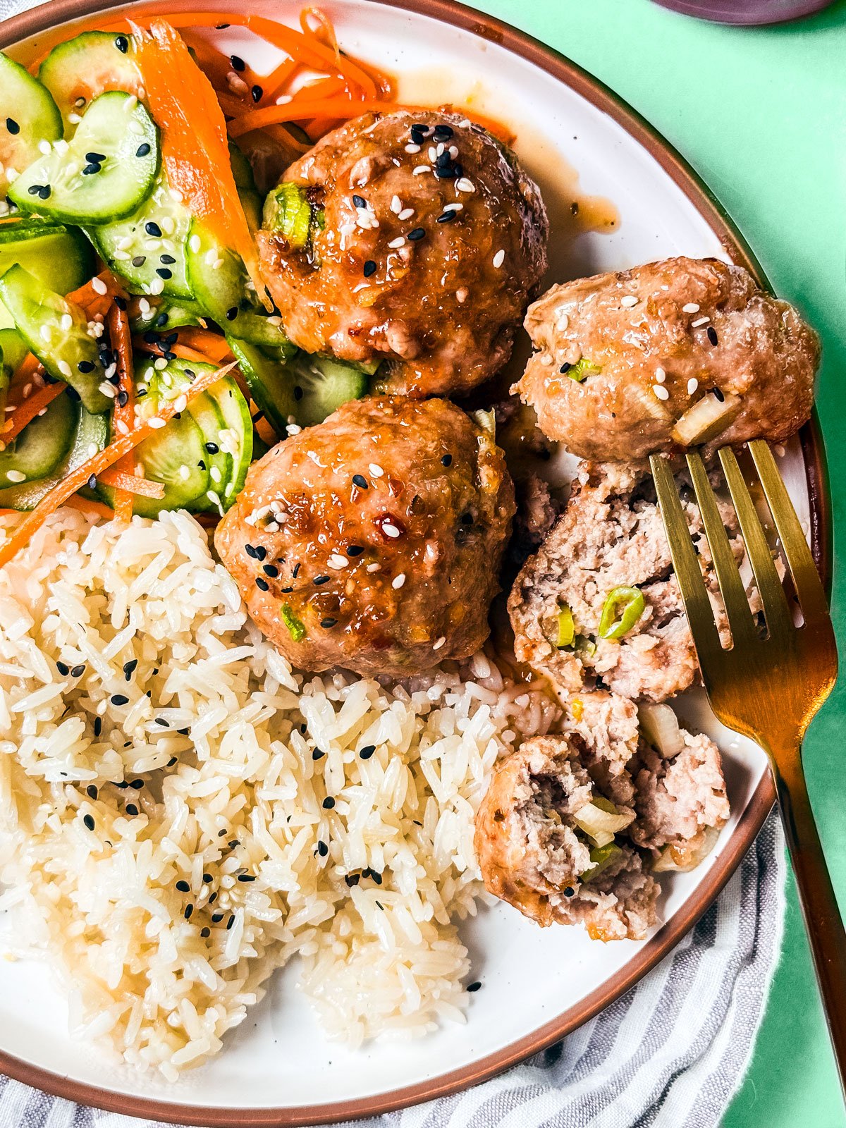 Baked turkey meatballs with honey glaze on a plate with rice.