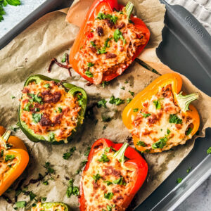 Cheesy stuffed peppers on a baking sheet.