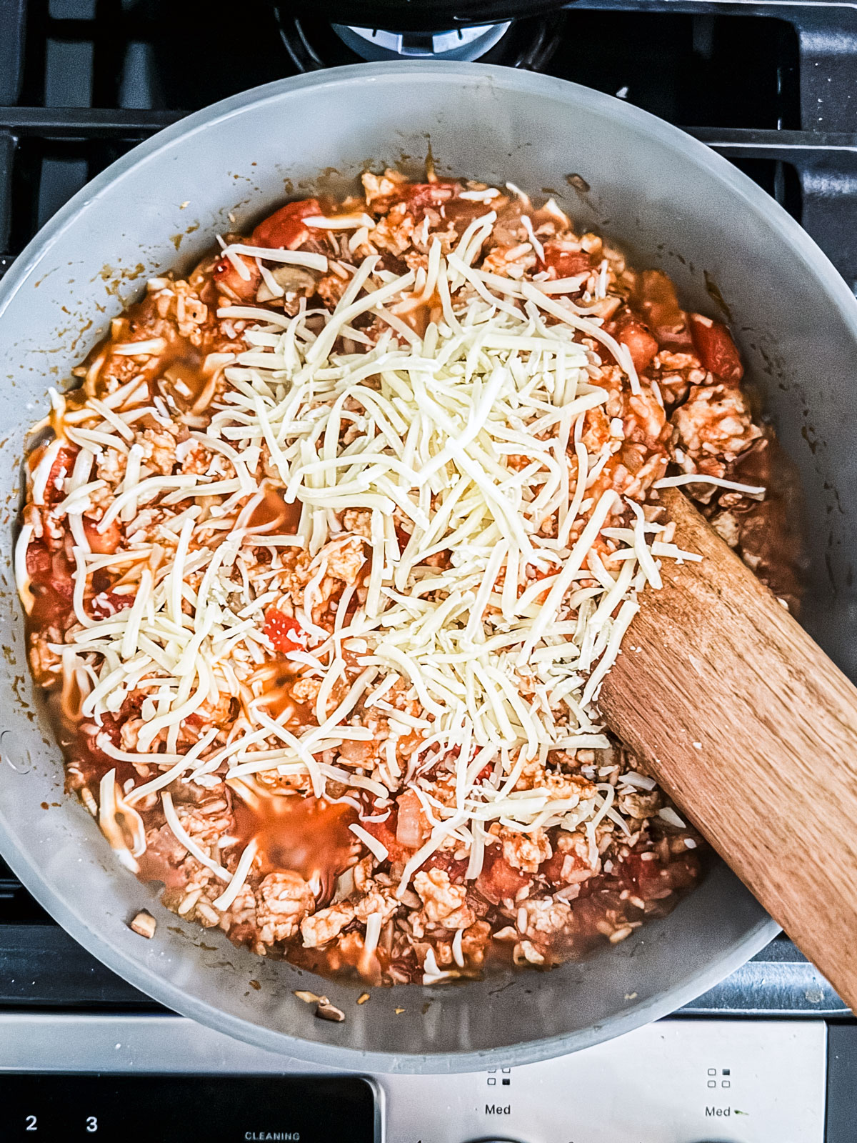 Saucy ground turkey sprinkled with cheese in a skillet.