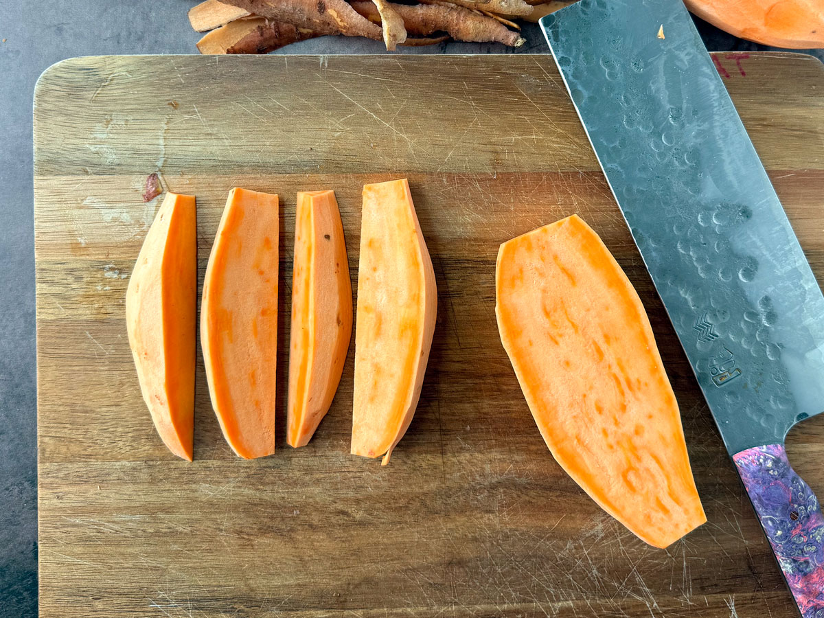 Sweet potato wedges on a cutting board.