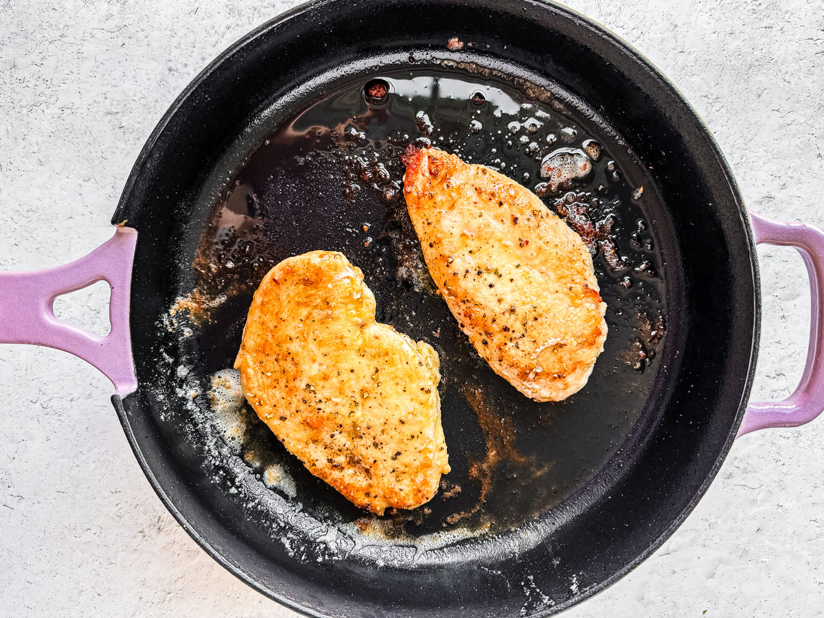 Skillet with golden cooked chicken cutlets.