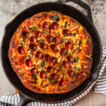 Pizza in cast iron skillet.