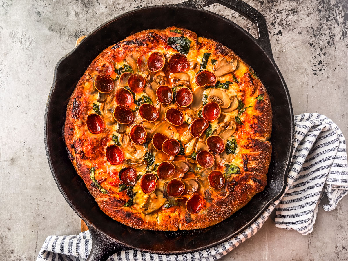 Cooked pizza in a cast iron skillet.