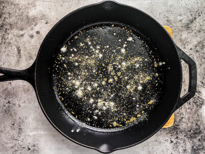 Cast iron pan with flour and cornmeal sprinkled into it.