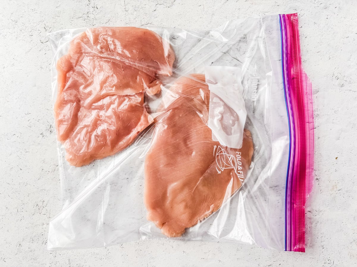 Pounded chicken cutlets on a white background.